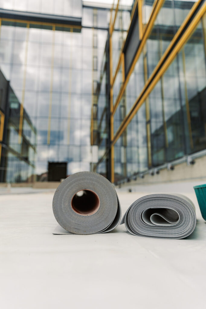 Two rolls of TPO sitting on a newly installed roofing system