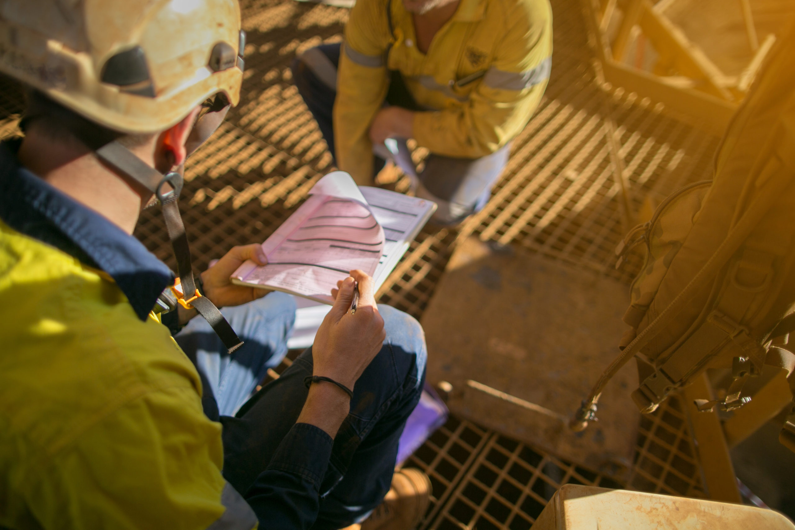 construction worker looking over building permit as he and his co-worker prepare for their morning shift