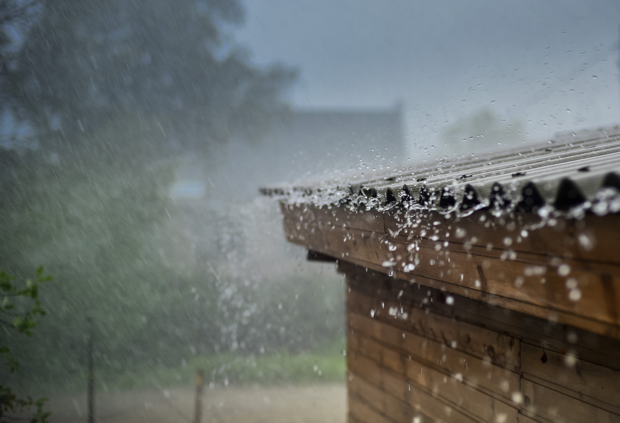 heavy rain flows off of a roof