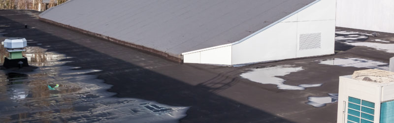 Large commercial roof with water pooling