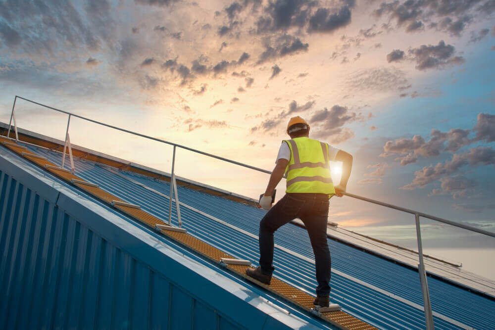 Worker inspecting a commercial metal roof