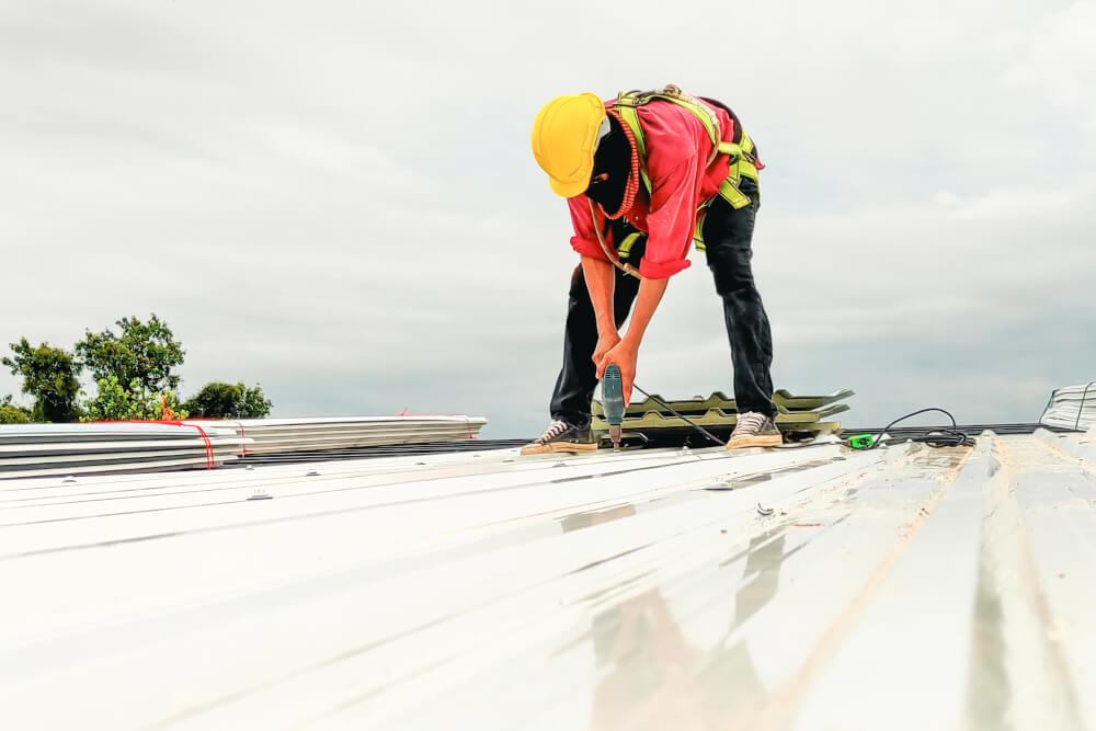 Working replacing metal tiles on a roof